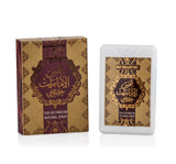 The image shows a product from the "OUD COLLECTION" which includes a perfume box and a bottle. The box is maroon with intricate golden patterns and an elaborate central medallion featuring Arabic calligraphy in gold. The English text "EAU DE PARFUM NATURAL SPRAY" is written below the medallion. To the right is a white, rectangular perfume bottle with a label that mirrors the design of the box, including the Arabic calligraphy and the same text in English at the bottom.
