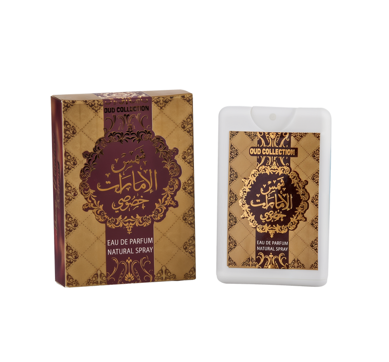 The image shows a product from the "OUD COLLECTION" which includes a perfume box and a bottle. The box is maroon with intricate golden patterns and an elaborate central medallion featuring Arabic calligraphy in gold. The English text "EAU DE PARFUM NATURAL SPRAY" is written below the medallion. To the right is a white, rectangular perfume bottle with a label that mirrors the design of the box, including the Arabic calligraphy and the same text in English at the bottom.