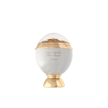 The image shows an elegant perfume bottle designed in the shape of an ornate sphere. The bottle is predominantly white with gold accents, including a gold base and a gold band around the middle. The top half of the bottle is transparent, showcasing intricate floral decorations inside. The label on the front reads "Souvenir Floral Bouquet by Afnan" in stylish, gold lettering.