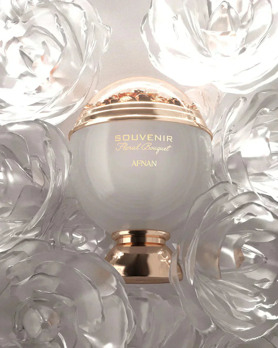 The image shows a perfume bottle with a clean and elegant design. The bottle has a spherical white body with a golden band that reads "SOUVENIR Floral Bouquet AFNAN." Above the band is a clear dome, encasing what appears to be a cluster of golden petals or flakes, giving a sense of luxury. The bottle rests on a golden pedestal base that complements the golden accents.