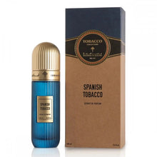 A product image featuring a blue perfume bottle with a ribbed texture and a golden cap, next to its packaging. The label on the bottle reads "SPANISH TOBACCO" in gold lettering. The packaging is a vertical rectangular box with a kraft paper texture and a navy blue top section, including a decorative label that reads "TOBACCO COLLECTION" and the Ibraheem Al Qurashi logo. The name "SPANISH TOBACCO" is also on the box in a larger font, indicating the fragrance's name.