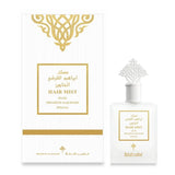 The image features a white packaging box and a perfume bottle, both adorned with gold accents. The box has a golden ornamental design at the top, with a central framed label stating "HAIR MIST MUSK IBRAHEEM ALQURASHI SPECIAL." The bottle mirrors this design with a similar label and a unique, ornate white cap that resembles an intricate architectural design. The label on the bottle also contains the same text as on the box.