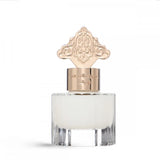 The image shows a clear glass perfume bottle with a frosted appearance, filled with a white liquid, suggesting a musk scent. The bottle has a distinctive gold cap with an ornate, arabesque design, indicative of Middle Eastern or Islamic artistic influence. Gold lettering in Arabic is present on the cap, likely denoting the fragrance name or brand. The design of the bottle cap adds a luxurious feel to the product, which is labeled as a special hair musk.
