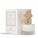 The image features a perfume bottle with a clear base and a milky white liquid, complemented by a decorative gold cap with an arabesque design. Next to the bottle is its packaging, a white box with gold and black text stating "MUSK IBRAHEEM AL QURASHI SPECIAL KHAMRIYA FOR HAIR," along with Arabic script. The side of the box displays a beige and white striped pattern. The design suggests that this is a luxurious hair musk fragrance with a special formulation.