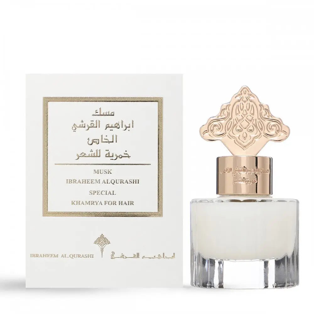 The image displays a transparent perfume bottle with a clear liquid and an ornate gold cap next to its white packaging box. The box has a label with a textured border, featuring both English and Arabic text that reads "MUSK IBRAHEEM AL.QURASHI SPECIAL KHAMRIYA FOR HAIR." The bottle's cap has intricate detailing that may draw inspiration from Middle Eastern or Islamic art.