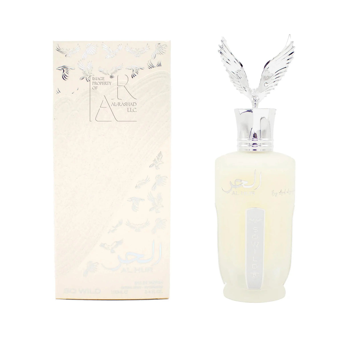 The image features two products placed against a white background: to the left is a vertical, rectangular perfume box and to the right is a corresponding perfume bottle. The box is off-white with an embossed pattern, adorned with silver embossed doves and has text indicating it is "AL HUR SO WILD 100ml by Ard Al Zaafaran," along with a watermark stating "IMAGE PROPERTY OF AL-RASHAD LLC." Both items have Arabic script and the bottle features a label with the words "SO WILD."  