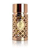 The image depicts a luxurious perfume bottle named "Jazzab Gold" from Ard Al Zaafaran. The bottle has a cylindrical shape with a geometric lattice design in a metallic rose gold finish, featuring diamond-shaped cutouts that reveal the dark liquid inside. The cap is smooth and rose gold, matching the body, and the top of the cap has a reflective surface. A gold label with the name "Jazzab" in Arabic calligraphy is prominently displayed in the center of the bottle. 