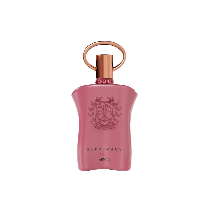 The image shows a pink perfume bottle with a metallic gold cap and a ring-shaped detail on top. The front of the bottle displays embossed text and a decorative emblem featuring the initials 'AP' in a stylized design, surrounded by a wreath-like motif. Below the emblem, the words "SUPREMACY GALA AFNAN" are printed in a simple, elegant font. The bottle has a smooth, matte finish, and there are small, pink gemstone-like embellishments around the neck.