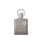 The image shows a perfume bottle with a sleek, modern design. The bottle is a muted silver-gray with a matte finish and a flat, rectangular shape. The cap is silver and features a prominent circular loop, which adds a touch of sophistication. Emblazoned on the front of the bottle is a raised silver emblem that adds a 3D effect, and below it, the words "SUPREMACY not only intense AFNAN" are printed in a subtle, elegant font. 