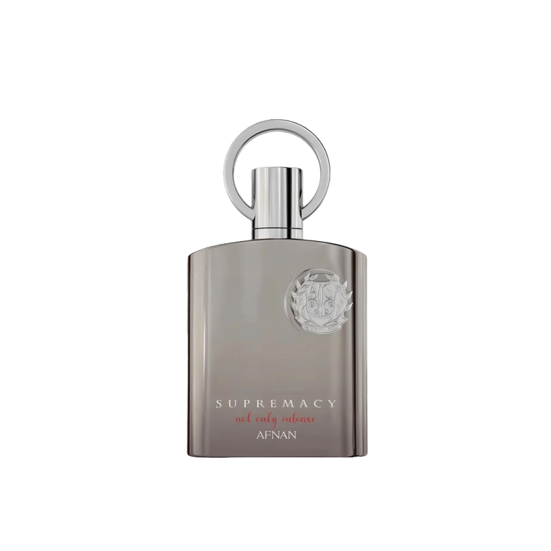 The image shows a perfume bottle with a sleek, modern design. The bottle is a muted silver-gray with a matte finish and a flat, rectangular shape. The cap is silver and features a prominent circular loop, which adds a touch of sophistication. Emblazoned on the front of the bottle is a raised silver emblem that adds a 3D effect, and below it, the words "SUPREMACY not only intense AFNAN" are printed in a subtle, elegant font. 