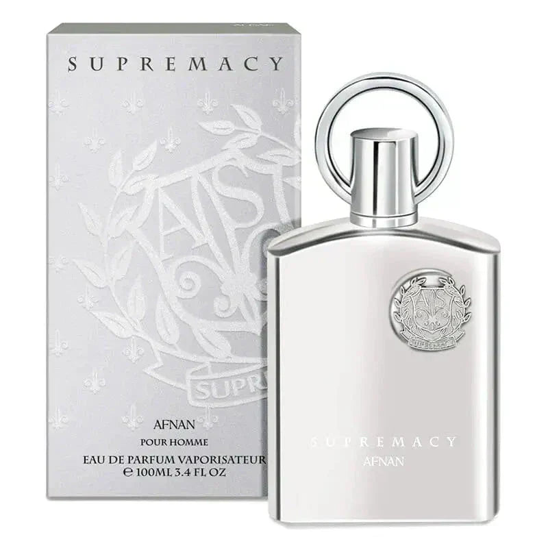 The image shows a product set from "AFNAN" featuring the "SUPREMACY" fragrance for men. On the left is the perfume's packaging box, which is a light grey with a subtle floral and vine embossed pattern, and the brand and product name printed in silver, reflective lettering. 