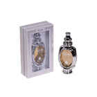 An image of Supreme Musk Eau de Parfum, showing the perfume bottle outside its packaging. The bottle has a traditional and ornate design, with a shiny black exterior and intricate silver accents. The label features the name "Supreme Musk" in elegant script. The packaging is a simple yet classy grey box with a window that allows the bottle to be viewed, bordered with ornamental patterns.