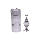 The image features two products on a white background. On the left, there is a cylindrical container with a silver chain, labeled "Supreme MUSK." Below the brand name is text that reads "Concentrated Perfume Oil 20ml." The container has a white label with elegant, decorative borders and a classic ornamental logo at the center. The top has an ornate design with a narrow middle that flares out at both ends, resembling a classic perfume applicator. 