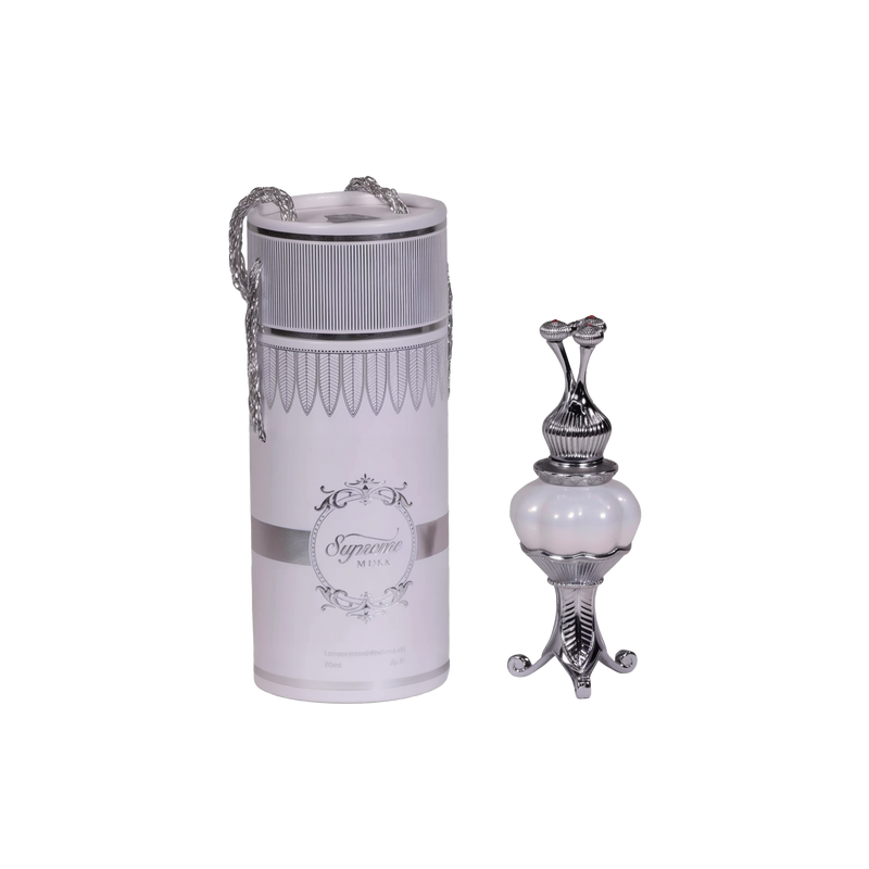 The image features two products on a white background. On the left, there is a cylindrical container with a silver chain, labeled "Supreme MUSK." Below the brand name is text that reads "Concentrated Perfume Oil 20ml." The container has a white label with elegant, decorative borders and a classic ornamental logo at the center. The top has an ornate design with a narrow middle that flares out at both ends, resembling a classic perfume applicator. 