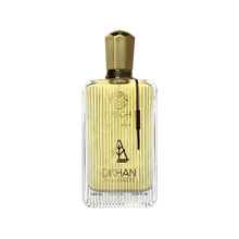 The image displays an elegant, clear glass perfume bottle with vertical ridges that create a textured effect. The liquid inside is a golden-yellow hue, evoking a sense of luxury and warmth. At the front of the bottle, the branding "TABGH INTENSE" is written in a sophisticated font, with the emblem "DKHAN FRAGRANCES" placed just below. A unique gold-colored cap tops the bottle, and there is a black vertical label on the right side with additional branding or fragrance information.