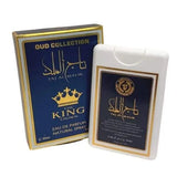 The image features two items from the "OUD COLLECTION." On the left is a dark blue box with gold lettering and detailing; it displays the name "TAJ AL MALIK" in both Arabic calligraphy and English, along with "THE KING CROWN" beneath it. The text "EAU DE PARFUM NATURAL SPRAY 20ml." is also visible. On the right is a white plastic case with a label that mirrors the box's design, holding the perfume inside.