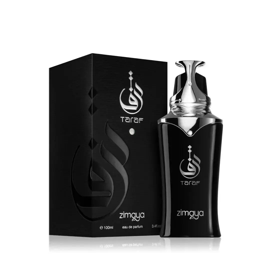  The image features the "Taraf" fragrance by Zimaya, showcasing both the perfume bottle and its packaging. The sleek, glossy black packaging box has the brand's logo and the fragrance name "Taraf" in a stylized, shiny silver font. The bottle mirrors this design with its polished black surface and silver accents. It has a unique shape, tapering towards the top with a silver spray nozzle and a protective cap that follows the contours of the bottle's design.