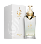 The image displays a bottle of Taraf eau de parfum zimaya alongside its packaging. The perfume bottle has a white to gold gradient design with a golden cap and is adorned with a logo that appears to be in Arabic script, and the brand name "Taraf" in gold lettering below it. The same logo and brand name are featured on the white textured packaging, with an embossed logo design adding a tactile element.