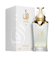 The image displays a bottle of Taraf eau de parfum zimaya alongside its packaging. The perfume bottle has a white to gold gradient design with a golden cap and is adorned with a logo that appears to be in Arabic script, and the brand name "Taraf" in gold lettering below it. The same logo and brand name are featured on the white textured packaging, with an embossed logo design adding a tactile element.