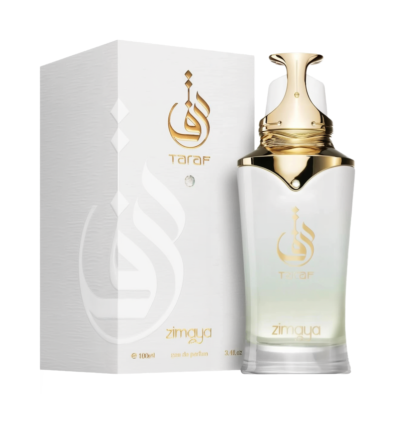 The image displays a bottle of Taraf eau de parfum zimaya alongside its packaging. The perfume bottle has a white to gold gradient design with a golden cap and is adorned with a logo that appears to be in Arabic script, and the brand name "Taraf" in gold lettering below it. The same logo and brand name are featured on the white textured packaging, with an embossed logo design adding a tactile element.