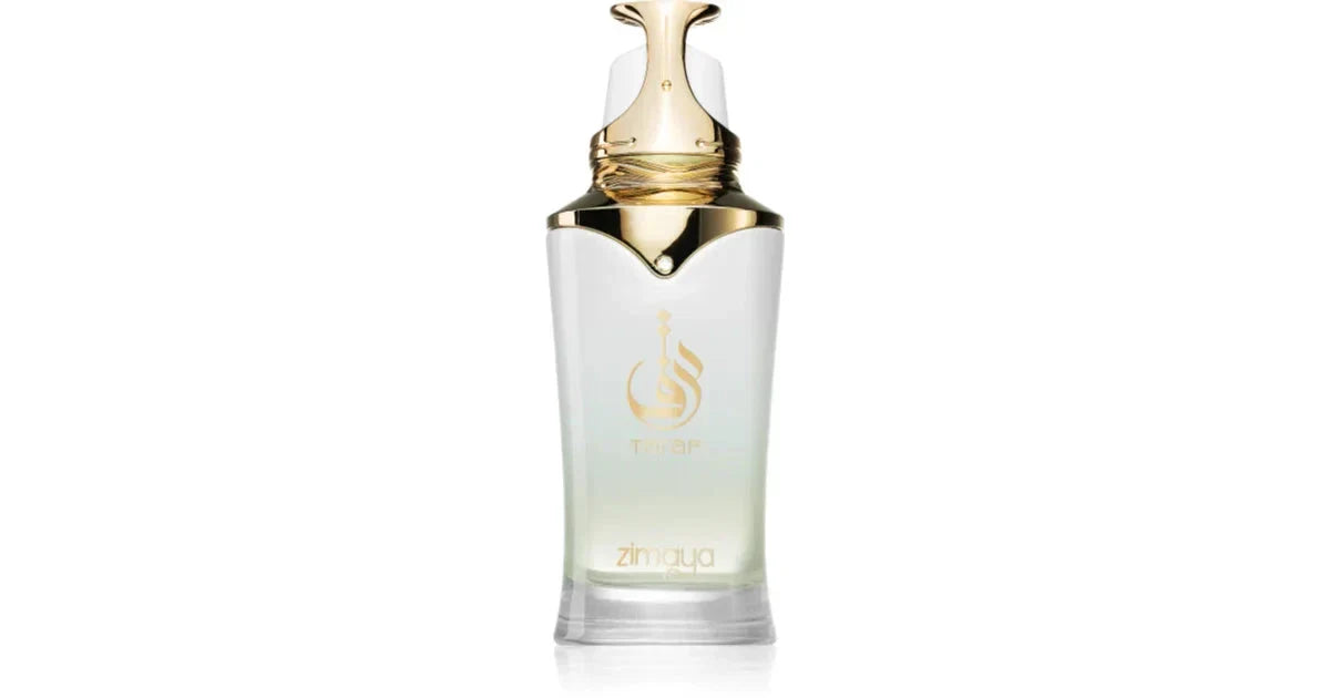 The image is of a Taraf White fragrance bottle by Zimaya. It features a sleek, glossy white bottle with a gold logo and text. The bottle has an elegant and modern design with a tapered neck and a distinctive, ornate gold cap that resembles a droplet. The cap also has a wrapped gold accent, adding to its luxurious appearance. The logo of Taraf is prominently displayed in the center of the bottle in gold with the word "zimaya" in smaller text below.