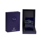 The image shows two items against a white background. On the left is a dark blue box with a matte finish and the brand name "Tribute by AFNAN" prominently displayed on the front. Below the name is additional text indicating that it is an "Eau de Parfum Vaporisateur" and the volume of "100ml, 3.4 FL. OZ." On the right side is an open box revealing a dark, navy blue interior with a textured surface. Inside the box is a vertical, ribbed navy blue panel.