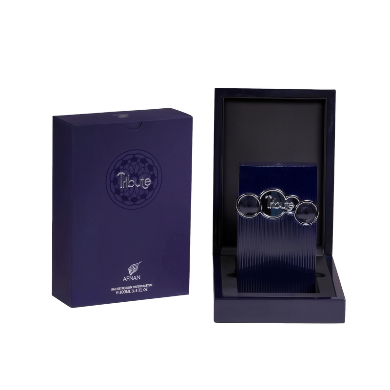 The image shows two items against a white background. On the left is a dark blue box with a matte finish and the brand name "Tribute by AFNAN" prominently displayed on the front. Below the name is additional text indicating that it is an "Eau de Parfum Vaporisateur" and the volume of "100ml, 3.4 FL. OZ." On the right side is an open box revealing a dark, navy blue interior with a textured surface. Inside the box is a vertical, ribbed navy blue panel.
