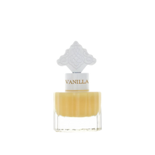 The image features a clear glass bottle with a yellow-colored liquid, suggestive of a vanilla-scented product. The bottle has a white cap with the word "VANILLA" printed on it in a color that complements the liquid. Atop the cap is a decorative white design with an intricate pattern, possibly inspired by Middle Eastern or Islamic art. The aesthetic of the bottle suggests an elegant fragrance, likely a special vanilla musk formulated for hair.