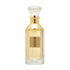 The image is of a perfume bottle:  The bottle has a rectangular shape with clear glass, revealing the golden-colored liquid perfume inside. It features a gold-colored neck and a white, bristle-like applicator that resembles a traditional shaving brush. The front of the bottle has a simple, elegant label with "VELVET OUD" in black letters and Arabic script below it.