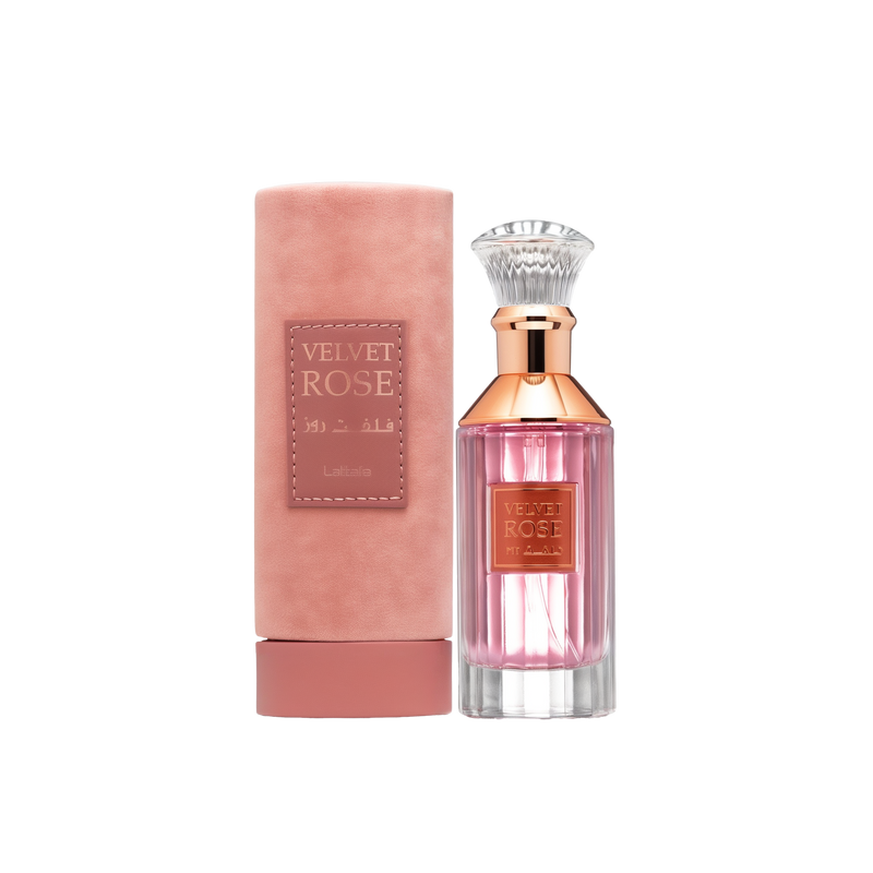 A cylindrical pink velvet container labeled ‘Velvet Rose’ by Lattafa, shown beside a clear glass perfume bottle containing pink liquid, featuring a rose-gold neck, a crystal-like cap, and a matching gold label on the front.
