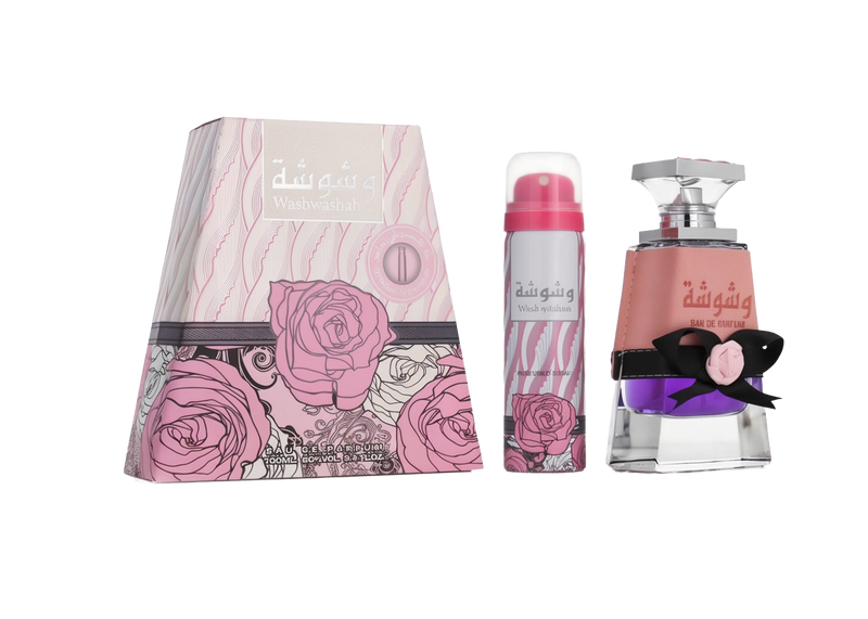 A triangular pink box with swirling rose designs, labeled “Washwashah” by Lattafa, shown alongside a matching pink aerosol spray can and a clear glass perfume bottle with purple liquid, a pink wraparound band, and a black bow accent.