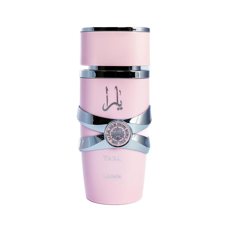 This image depicts a cylindrical, pale pink perfume bottle with the name "YARA" from the brand Lattafa. The bottle has a unique stacked design with silver bands wrapping around it, giving the appearance of three separate sections. The upper and lower sections are matte pink, while the middle section is glossy black, providing a striking contrast. A silver emblem with intricate detailing is centered on the middle band. The Arabic script, likely the name "YARA," is printed in black on the upper pink section.