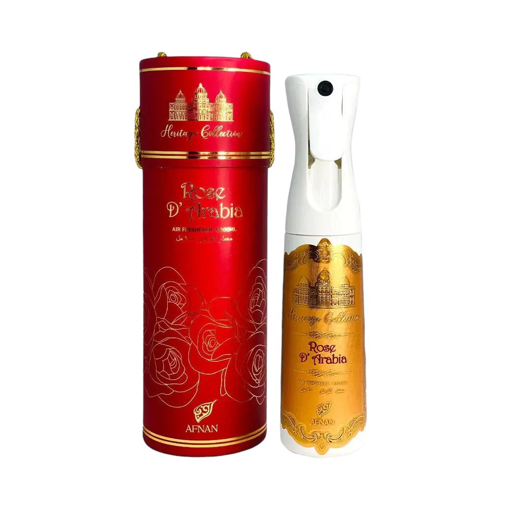 The image features an air freshener bottle with a corresponding cylindrical container. The container is red with golden accents, including a band at the top that reads "Heritage Collection" and a depiction of palatial architecture. It is also adorned with "Rose D'Arabia" in a stylized font amidst a pattern of rose illustrations.
