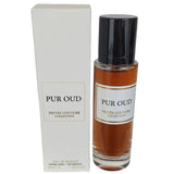 A bottle of "PUR OUD" eau de parfum from the "PRIVEE COUTURE COLLECTION" next to its packaging. The perfume bottle has a clear glass design with a dark cap and a golden-colored liquid inside, labeled with the product name in black text over a white label with a golden border. The white packaging box displays the same name and collection in black text with the additional detail "30ml e, 1.02 FL OZ" indicating the volume.