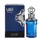 The image shows a perfume bottle with a deep blue glass body and a metallic silver cap with an ornamental loop design. The front of the bottle has the word "خفايا" in white Arabic script and "KHAFAYA" in Latin letters, with "zimaya" at the bottom. To the left, there's a textured blue box featuring a large white and black floral design on the top right corner, with the same "خفايا KHAFAYA" branding as on the bottle.