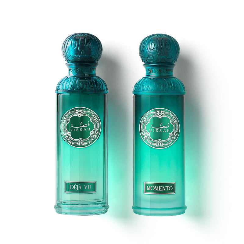 Gissah Déjà Vu and Momento turquoise perfume bottles with ornate teal caps side by side on white background.