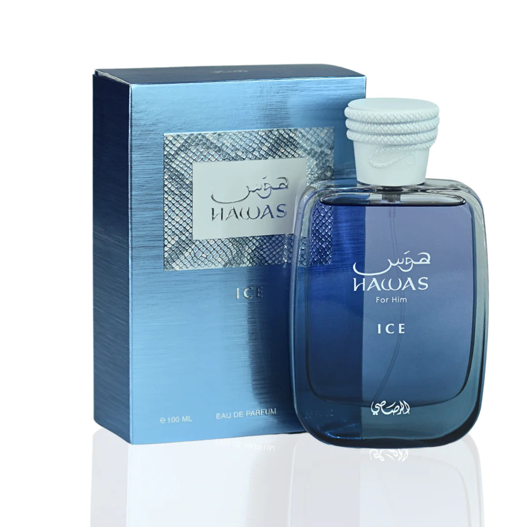 The image shows the HAWAS ICE For Him perfume, next to its packaging. The perfume bottle has a deep blue hue that fades to transparency towards the top, and it's capped with a white textured lid. There is Arabic script and English text on the bottle indicating the name. The packaging has a metallic blue finish with a textured design and a window revealing the bottle inside. It also includes the name HAWAS ICE in both Arabic and English and states the content as "Eau de Parfum" and the quantity as "100 ML".