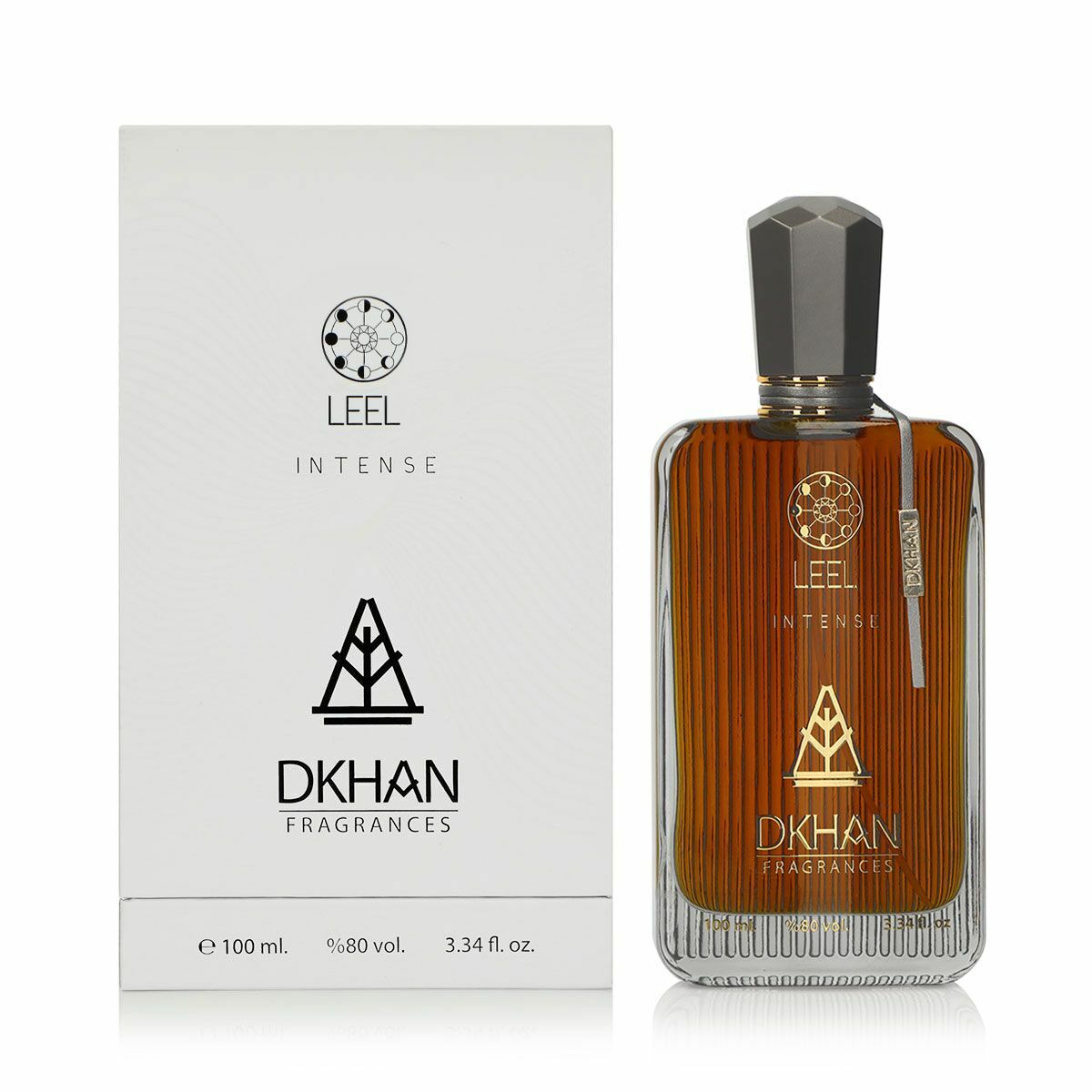The image displays a rectangular glass perfume bottle with an amber-colored fragrance, labeled "LEEL INTENSE" at the front, along with the "DKHAN FRAGRANCES" emblem. The bottle has a black faceted cap, a label on the right side, and rests on a clear glass base. Beside the bottle stands its white packaging box, which mirrors the bottle's branding with the name "LEEL INTENSE" and the emblem "DKHAN FRAGRANCES" printed in black.