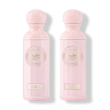 The image features two light pink perfume bottles from the "Legend of the Sky for Her" collection by Gissah, named "Sora" and "Ellora." The bottles have a cylindrical shape with detailed ornamental designs embossed on the silver caps and the central gold medallions. The names "Sora" and "Ellora" are inscribed on gold plaques at the base of each bottle. 